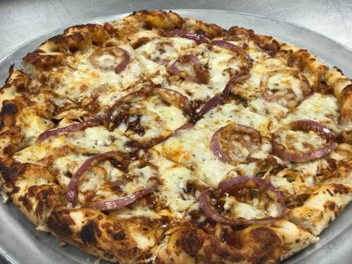 A freshly baked pizza topped with melted cheese, barbecue sauce, and sliced red onions on a golden crust.