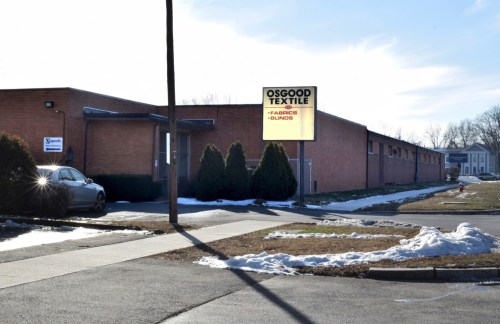 Exterior view of Osgood Textile building with a sign, surrounded by snow and a clear sky.