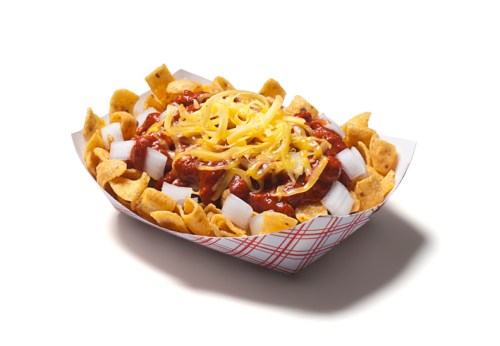 A serving of Frito pie with chili, shredded cheese, and diced onions in a paper tray.