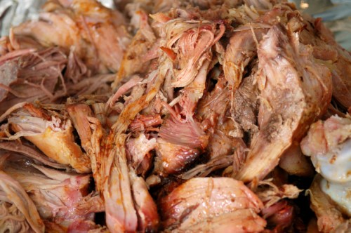 Close-up of shredded, cooked meat piled together, showcasing a mix of textures and colors.