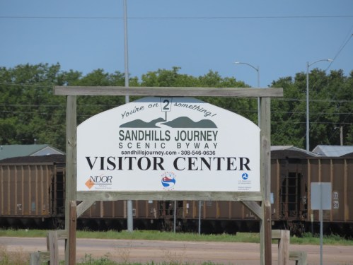 Sign for the Sandhills Journey Scenic Byway Visitor Center, featuring contact information and scenic route details.