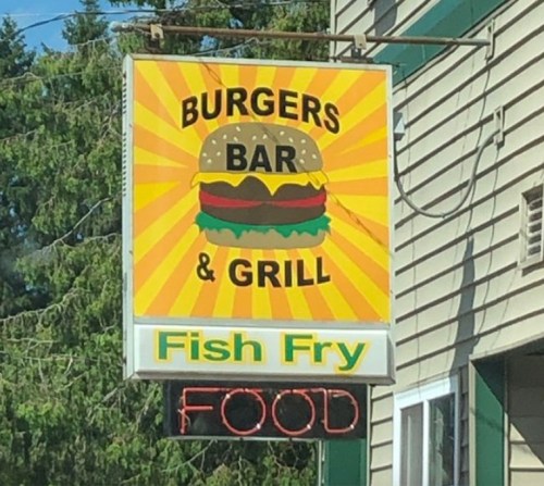 Sign for a restaurant featuring "Burgers Bar & Grill" with a burger graphic and "Fish Fry" below. Neon "FOOD" sign.