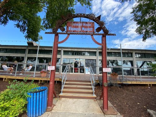 Entrance to the Freight House Farmers Market, featuring a decorative arch and outdoor seating area.