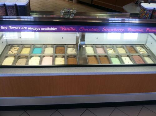 A display case filled with various ice cream flavors, including vanilla, chocolate, strawberry, and mint.