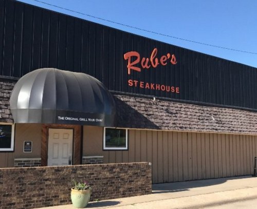 Exterior of Rube's Steakhouse featuring a distinctive rounded entrance and a sign with the restaurant's name.