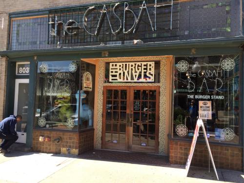 Exterior of a restaurant called "The Casbah," featuring a sign for "The Burger Stand" and decorative windows.