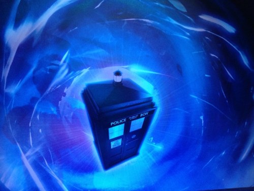 A blue police box surrounded by swirling blue light, resembling a time portal.