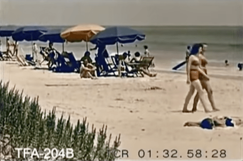 A beach scene with umbrellas, lounge chairs, and people enjoying the sun and water.