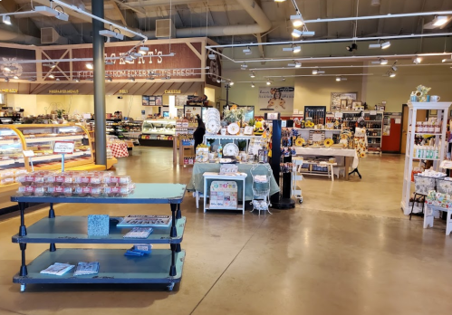 A spacious store interior featuring displays of baked goods, gifts, and various products in a bright, inviting atmosphere.