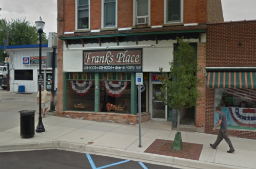 A street view of Franks Place, a restaurant with patriotic decorations, featuring a "dine-in/carry out" sign.