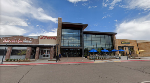 Exterior view of a shopping center featuring JCPenney, a burger bar, and a restaurant with outdoor seating.