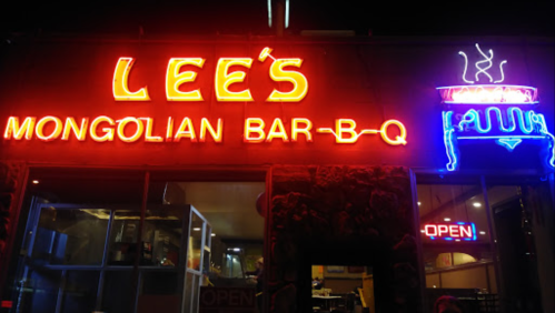 Neon signs for "Lee's Mongolian Bar-B-Q" and "Open" illuminate the restaurant's exterior at night.