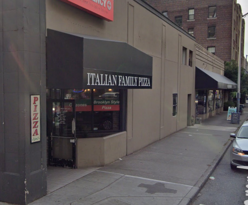 Exterior of Italian Family Pizza restaurant with a sign, sidewalk, and nearby buildings in an urban setting.