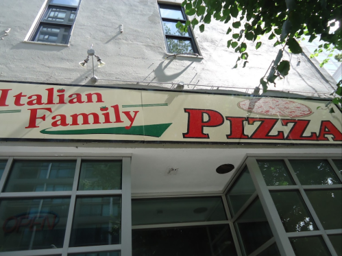 Sign for "Italian Family Pizza" on a building, featuring a pizza graphic and green accents.