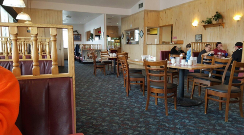 A cozy diner interior with wooden chairs, tables, and patrons enjoying their meals in a relaxed atmosphere.