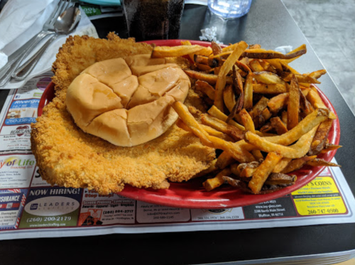 A plate with a fried chicken sandwich and a side of crispy French fries.