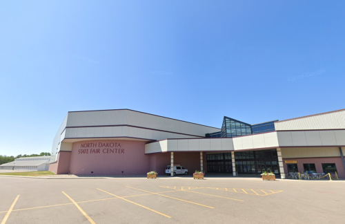 Exterior view of the North Dakota State Fair Center on a clear day, featuring a modern architectural design.