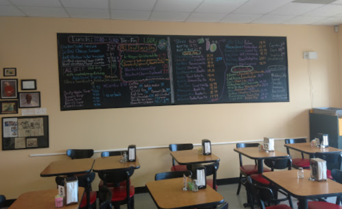 Chalkboard menu in a restaurant displaying lunch specials, prices, and various food options on a wall.