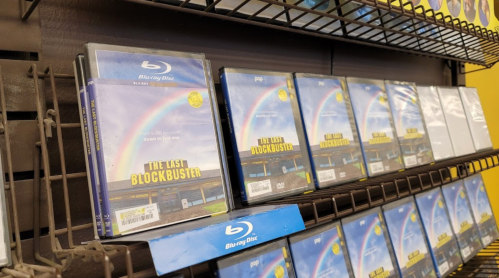 Blu-ray discs displayed on a shelf, featuring "The Last Blockbuster" with a rainbow in the background.