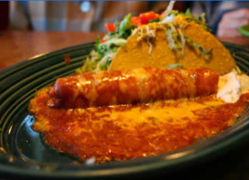 A plate featuring a cheese enchilada topped with red sauce and a taco filled with lettuce and tomatoes.
