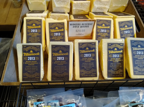 A display of Tillamook cheese wedges labeled "Makers Reserve 2013" with a price tag of $29.99.