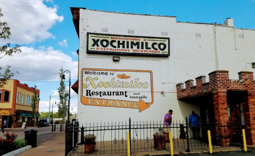 A white building with a sign reading "Xochimilco Restaurant Mexicano" and "Welcome to Xochimilco Restaurant and Cocktails."