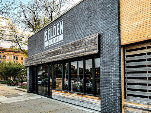Exterior of Selden Standard restaurant featuring a modern facade with wood accents and large glass windows.
