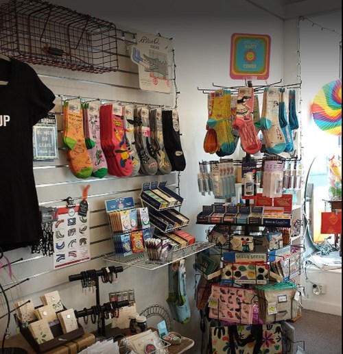 A colorful display of socks, accessories, and gifts in a retail shop, with various items hanging on walls and shelves.
