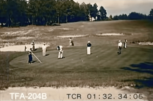 A vintage scene of golfers on a green, with several players preparing to putt and others observing.