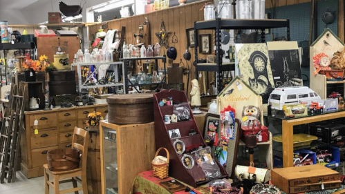 A cozy antique shop filled with vintage items, furniture, and decorative pieces on display.