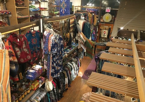 A vibrant store interior filled with colorful clothing and accessories displayed on racks and shelves.