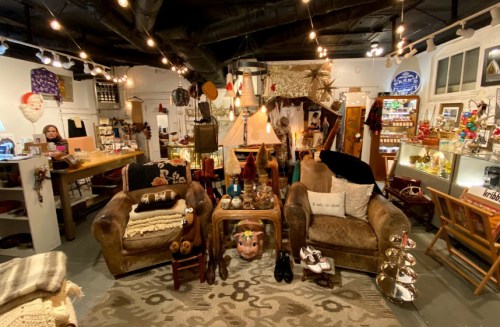 Cozy vintage shop interior with eclectic decor, comfortable seating, and warm lighting.
