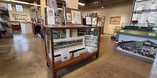 Display case in a museum featuring historical sports memorabilia and photographs.