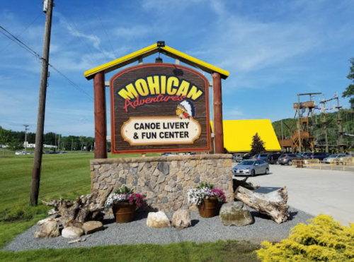 Sign for Mohican Adventures Canoe Livery & Fun Center, featuring colorful design and landscaped entrance.