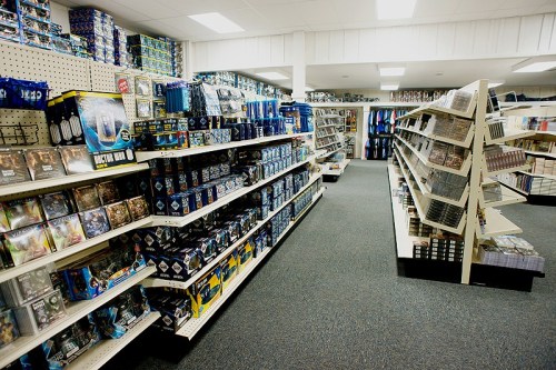 A well-organized store aisle filled with various merchandise, including games, toys, and collectibles on shelves.
