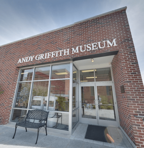 Entrance of the Andy Griffith Museum, featuring a brick facade and a bench outside.
