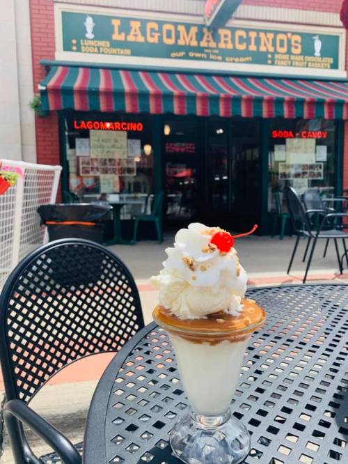 A delicious sundae topped with whipped cream and a cherry, set outside Lagomarcino's ice cream shop.