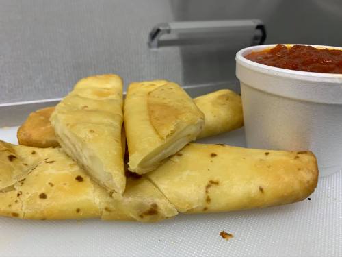 A plate of golden-brown stuffed breadsticks with a side of marinara sauce.