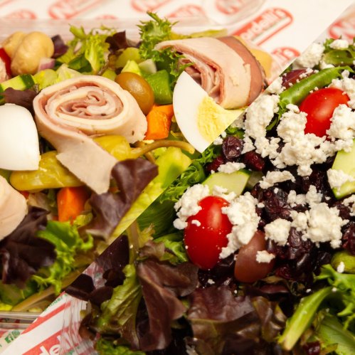 Two colorful salads: one with rolled turkey, eggs, and mixed veggies; the other with cherry tomatoes, olives, and feta.