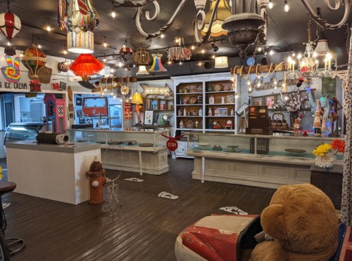 A whimsical shop interior filled with vintage decor, colorful lights, and display cases, creating a nostalgic atmosphere.