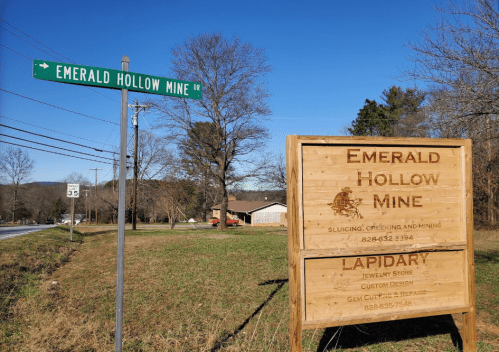 Sign for Emerald Hollow Mine with directions and information about the lapidary and jewelry store nearby.