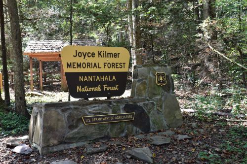 Sign for Joyce Kilmer Memorial Forest in Nantahala National Forest, surrounded by trees and natural scenery.