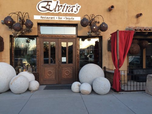 Exterior of Elvira's restaurant featuring large decorative stones and hanging lanterns, with a red curtain at the entrance.