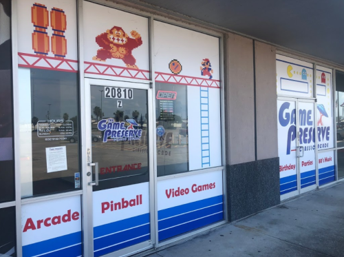 Exterior of Game Preserve arcade featuring pixel art, arcade games, and a welcoming entrance.