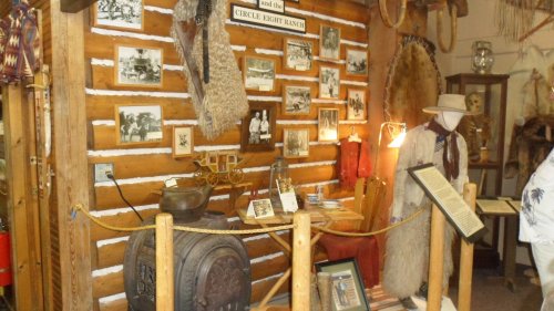 Display of historical artifacts and photographs in a rustic wooden setting, showcasing the Circle Eight Ranch.