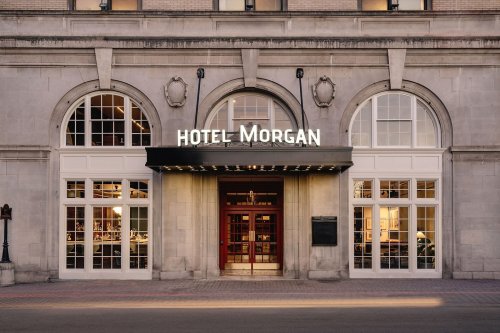 Front entrance of Hotel Morgan, featuring large arched windows and a stylish sign above the door.
