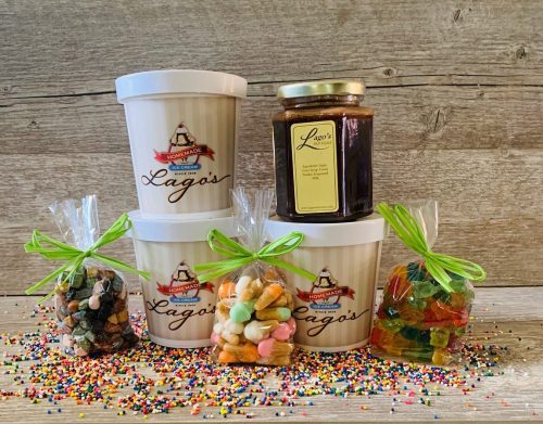 Assorted jars and bags of colorful candies and treats from Lago's, displayed on a wooden surface with sprinkles.