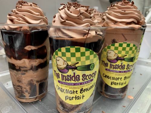 Three cups of chocolate brownie parfaits topped with chocolate whipped cream and sprinkles, labeled "The Inside Scoop."