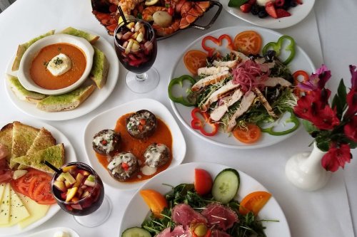 A vibrant spread of various dishes, including salads, seafood, and drinks, beautifully arranged on a table.