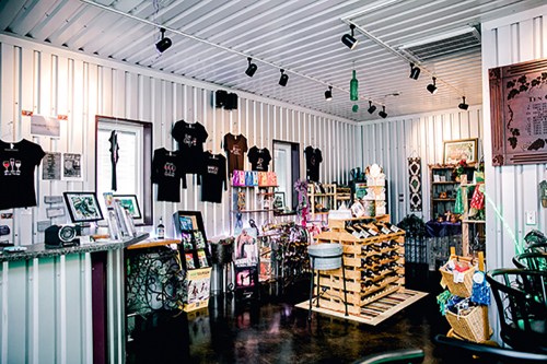 A cozy shop interior with merchandise displays, including clothing, art, and decor, set in a modern space.